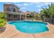 Backyard view of a pool with a safety fence, green lawn and attractive home exterior at 1553 Ravanusa Dr, Henderson, NV 89052