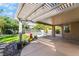 A covered patio overlooking a beautiful backyard with a pool and mature landscaping at 1553 Ravanusa Dr, Henderson, NV 89052