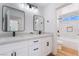 Modern bathroom with dual sinks, framed mirrors, and sleek black hardware at 1553 Ravanusa Dr, Henderson, NV 89052