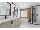 Bright bathroom featuring dual vanity, soaking tub, and a sleek glass-enclosed shower at 1553 Ravanusa Dr, Henderson, NV 89052