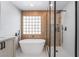 Modern bathroom showcasing a freestanding tub, tiled wall, and a glass-enclosed shower at 1553 Ravanusa Dr, Henderson, NV 89052