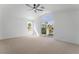 Spacious bedroom with balcony access, large window, and neutral carpet at 1553 Ravanusa Dr, Henderson, NV 89052