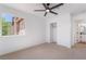Bright bedroom featuring a ceiling fan, neutral carpeting, closet and sunny window view at 1553 Ravanusa Dr, Henderson, NV 89052