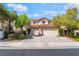 Charming two-story home featuring a red tile roof, spacious driveway, and lush landscaping at 1553 Ravanusa Dr, Henderson, NV 89052