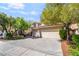 Charming two-story home with a red tile roof, a spacious driveway, and mature trees at 1553 Ravanusa Dr, Henderson, NV 89052