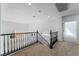 Hallway with modern black railing on staircase and light neutral colored carpet at 1553 Ravanusa Dr, Henderson, NV 89052