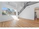 Bright living room with high ceilings, wood floors, and a staircase with iron railings at 1553 Ravanusa Dr, Henderson, NV 89052