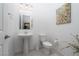 Clean bathroom with pedestal sink, toilet, flowers and modern fixtures at 174 Cabo Cruces Dr, Henderson, NV 89011