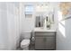 Clean, bright bathroom with a modern vanity, toilet, and shower with white curtain at 174 Cabo Cruces Dr, Henderson, NV 89011
