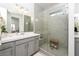 Bright bathroom with a gray vanity, modern fixtures, and a glass enclosed shower with a built-in bench at 174 Cabo Cruces Dr, Henderson, NV 89011