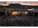 Charming home exterior with a cozy patio and mountain views at twilight at 174 Cabo Cruces Dr, Henderson, NV 89011