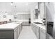 Modern kitchen with stainless steel appliances, gray cabinets, and quartz countertops at 174 Cabo Cruces Dr, Henderson, NV 89011
