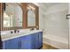 Modern bathroom features a dual sink vanity, wood accent wall, and a shower-tub combination at 2110 Los Feliz St # 1003, Las Vegas, NV 89156