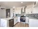 Updated kitchen with white cabinets, stainless appliances, and a modern backsplash plus a decorative fireplace at 2110 Los Feliz St # 1003, Las Vegas, NV 89156
