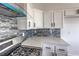 Bright kitchen featuring a gas stove, white cabinets, and marble countertops against stone backsplash at 2110 Los Feliz St # 1003, Las Vegas, NV 89156