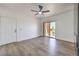 Bright living room with wood-look floors, white walls, ceiling fan, and sliding glass door to a balcony at 2110 Los Feliz St # 1003, Las Vegas, NV 89156