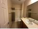 Well-lit bathroom featuring a single sink vanity, tile flooring, and a shower-tub combination with curtain at 2224 Waterton Rivers Dr, Henderson, NV 89044