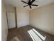 Cozy bedroom with neutral carpet, featuring a ceiling fan, closet with sliding doors, and a bright window at 2224 Waterton Rivers Dr, Henderson, NV 89044