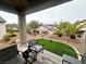 A covered back patio features artificial turf, desert landscaping, and comfortable seating area at 2558 Divine Sky Dr, Henderson, NV 89044