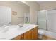 Bright bathroom featuring an oak vanity, a sink, a mirror, a toilet, and a shower-tub combo at 2558 Divine Sky Dr, Henderson, NV 89044