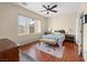Relaxing bedroom with wooden floors, ceiling fan, and natural light at 2558 Divine Sky Dr, Henderson, NV 89044