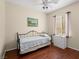 Bright bedroom featuring wood floors, ceiling fan, iron bed frame, and a three-drawer bedside table at 2558 Divine Sky Dr, Henderson, NV 89044