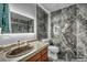 Modern bathroom featuring gray marble tile, granite countertop, and lighted mirror at 2725 S Nellis Blvd # 2052, Las Vegas, NV 89121