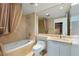 Elegant bathroom with a soaking tub, vanity, and large mirror with a view to the closet at 2857 Paradise Rd # 802, Las Vegas, NV 89109