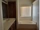 Well-lit bathroom with a built-in tub, neutral color palette and dark wood cabinetry at 2920 Malibou Ave, Pahrump, NV 89048