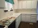 Galley kitchen featuring white cabinets, tile counters and modern appliances at 2920 Malibou Ave, Pahrump, NV 89048