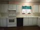 Galley style kitchen with white cabinets, white appliances and vinyl floors at 2920 Malibou Ave, Pahrump, NV 89048