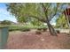 Picturesque backyard with mature tree coverage, low-maintenance gravel, and golf course views at 2929 Haddon Dr, Las Vegas, NV 89134