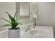Close-up of a white bathroom sink with a silver faucet and a potted plant on the counter at 2929 Haddon Dr, Las Vegas, NV 89134