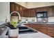 Kitchen featuring dark cabinets, modern appliances, and a dual basin sink at 2929 Haddon Dr, Las Vegas, NV 89134