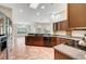 Open kitchen with dark cabinets, tile floor, island, and plenty of natural light at 2929 Haddon Dr, Las Vegas, NV 89134
