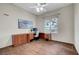 Home office with wood flooring, ceiling fan, large window, and built-in desk and drawers at 2929 Haddon Dr, Las Vegas, NV 89134