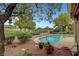 Backyard swimming pool surrounded by mature trees, landscaping, and a view of the golf course at 2929 Haddon Dr, Las Vegas, NV 89134