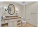 Well-lit bathroom featuring granite countertops, decorative sconces, and toilet at 30 Strada Di Villaggio # 306, Henderson, NV 89011