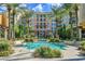 Exterior view of building with multiple balconies overlooking the community pool area surrounded by palm trees at 30 Strada Di Villaggio # 306, Henderson, NV 89011