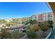 Beautiful view of the community pool, surrounded by lush landscaping, multiple buildings, and clear blue skies at 30 Strada Di Villaggio # 306, Henderson, NV 89011