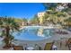 Relaxing community pool area with lounge chairs, landscaped surroundings and palm trees on a clear, sunny day at 30 Strada Di Villaggio # 306, Henderson, NV 89011