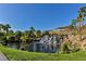 Picturesque waterfall cascading into a tranquil pond, surrounded by lush greenery and mature palm trees at 30 Strada Di Villaggio # 306, Henderson, NV 89011