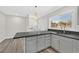 Updated kitchen with gray cabinets, stainless steel appliances, granite countertops, and a window overlooking the backyard at 3101 Greenbriar Dr, Las Vegas, NV 89121