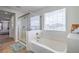 Bright bathroom featuring a soaking tub, glass enclosed shower, and a window for natural light at 3237 Mist Effect Ave, Henderson, NV 89044