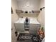 Convenient laundry room with modern washer and dryer, stylish wallpaper, and organized shelving at 369 Stone Fly Rd, North Las Vegas, NV 89032