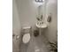 Elegant powder room with a pedestal sink, modern fixtures and white tiled floor at 369 Stone Fly Rd, North Las Vegas, NV 89032