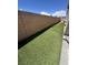 Side yard view showcasing artificial turf running alongside a brick wall, offering low maintenance at 369 Stone Fly Rd, North Las Vegas, NV 89032
