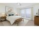 This staged primary bedroom is furnished with a bed and has two large windows at 3770 Shirebrook Dr # 160, Las Vegas, NV 89115