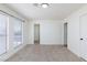 This empty bedroom has neutral carpet, a closet, and a large window at 3770 Shirebrook Dr # 160, Las Vegas, NV 89115