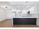 Modern kitchen featuring white cabinets, a dark island, and sleek countertops with stainless steel appliances at 3770 Shirebrook Dr # 160, Las Vegas, NV 89115